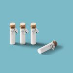 Four white bottles with cork lids.