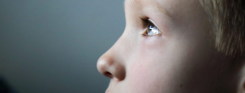 Portrait of 7 years old boy in front of screen