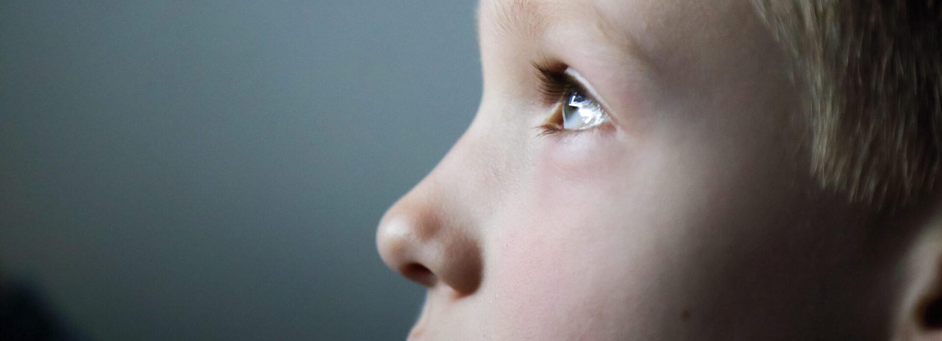 Portrait of 7 years old boy in front of screen