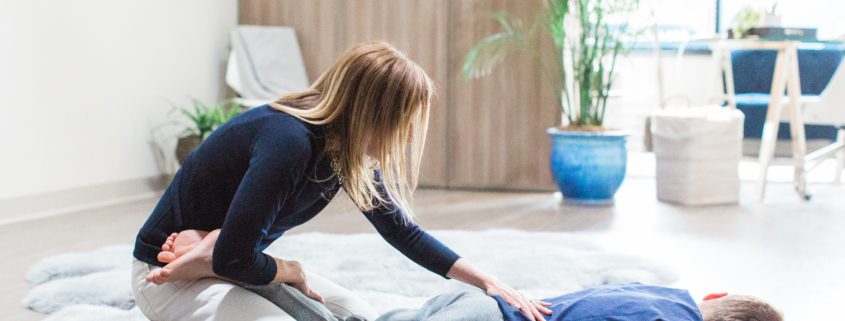 A Woman Helping With Setting the Back of a Person on an Area Rug