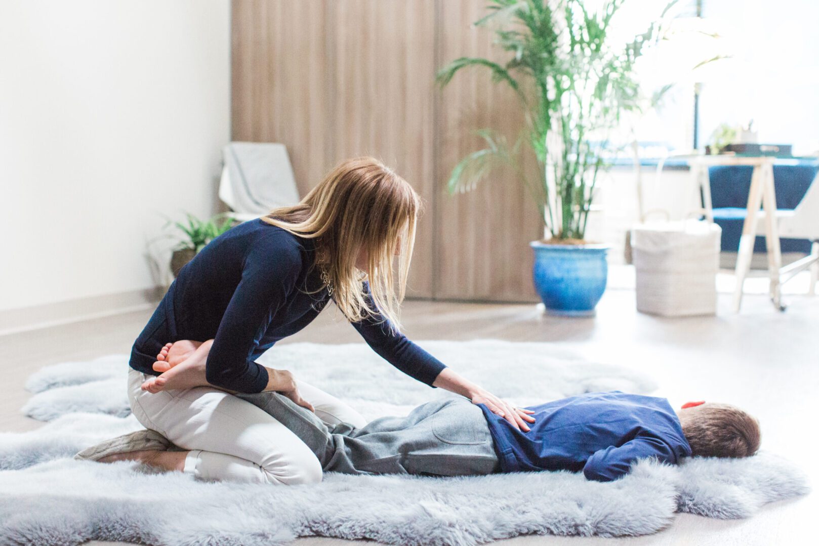 A Woman Helping With Setting the Back of a Person on an Area Rug