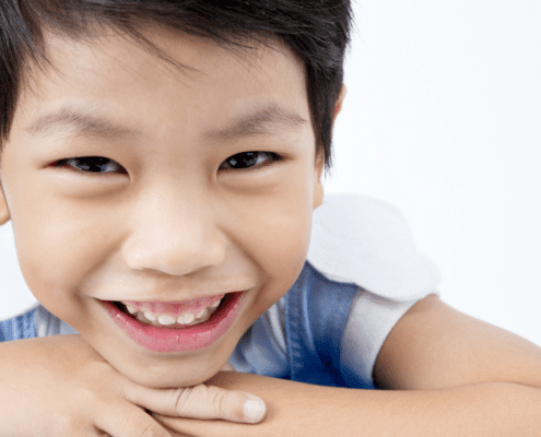 Smiling boy with short black hair.