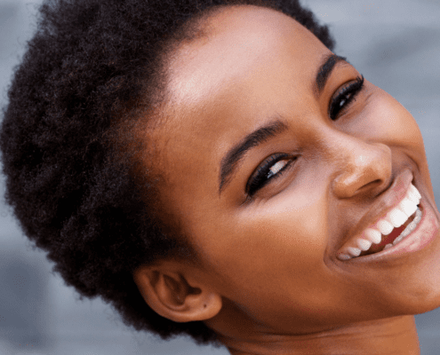 Smiling woman with short, curly hair.