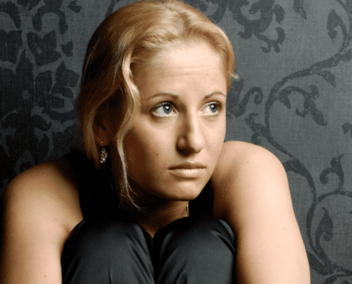 Woman with short blonde hair, deep in thought.