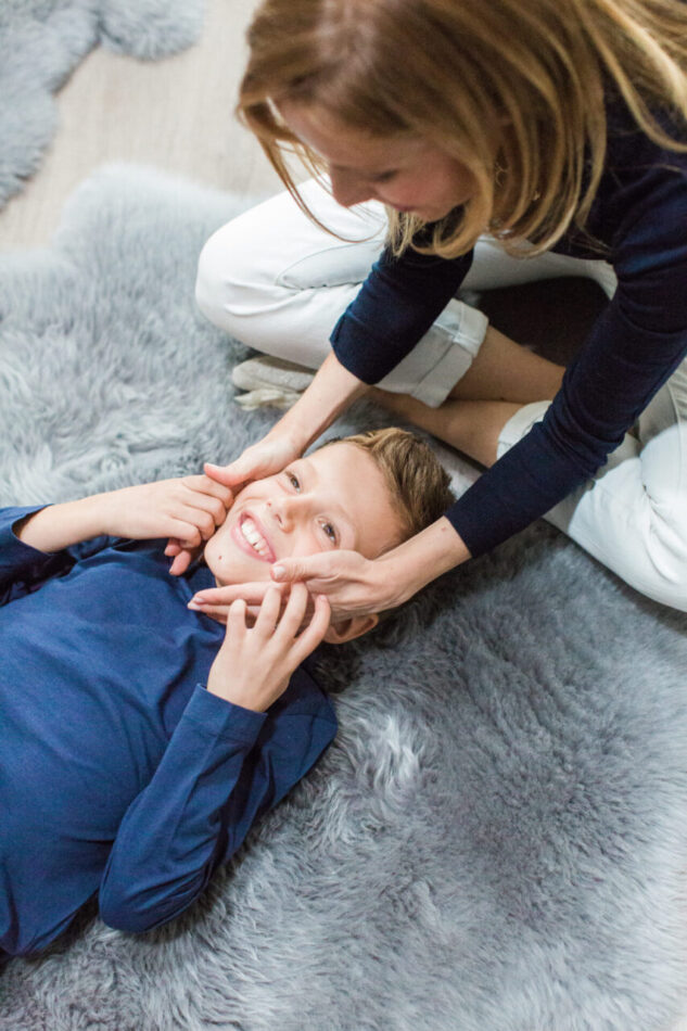 Child smiling while being playful with adult.