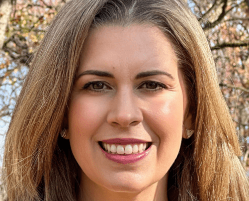Smiling woman in a forest setting.