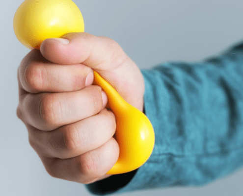 Hand holding a yellow dumbbell.