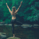 Woman doing yoga pose by a river.