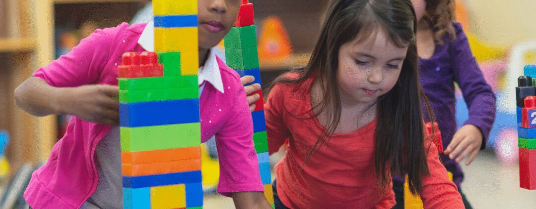 Children building towers with colorful plastic blocks.