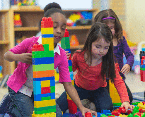 Children building towers with colorful plastic blocks.