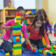 Children building towers with colorful plastic blocks.