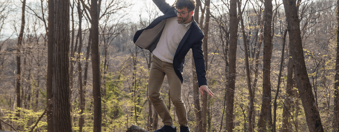 Man balancing on a fallen tree trunk.