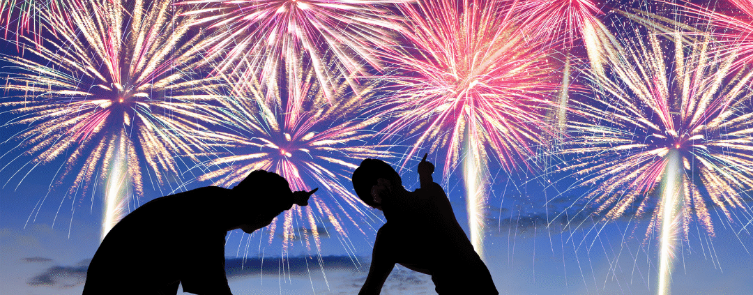 Family watching colorful fireworks in sky.