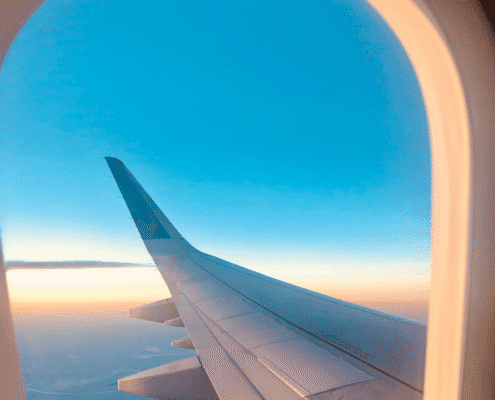Airplane wing view at sunset from window.