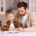Father helping son with homework at table.