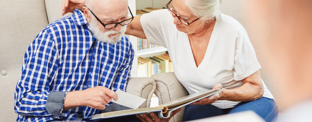 Elderly couple looking at a photo album.