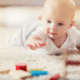 Baby reaching for colorful wooden blocks.