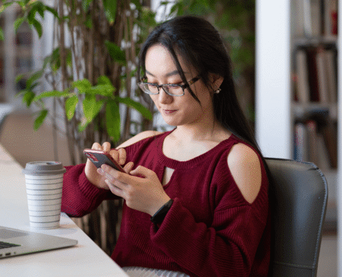 Woman using smartphone in a library.