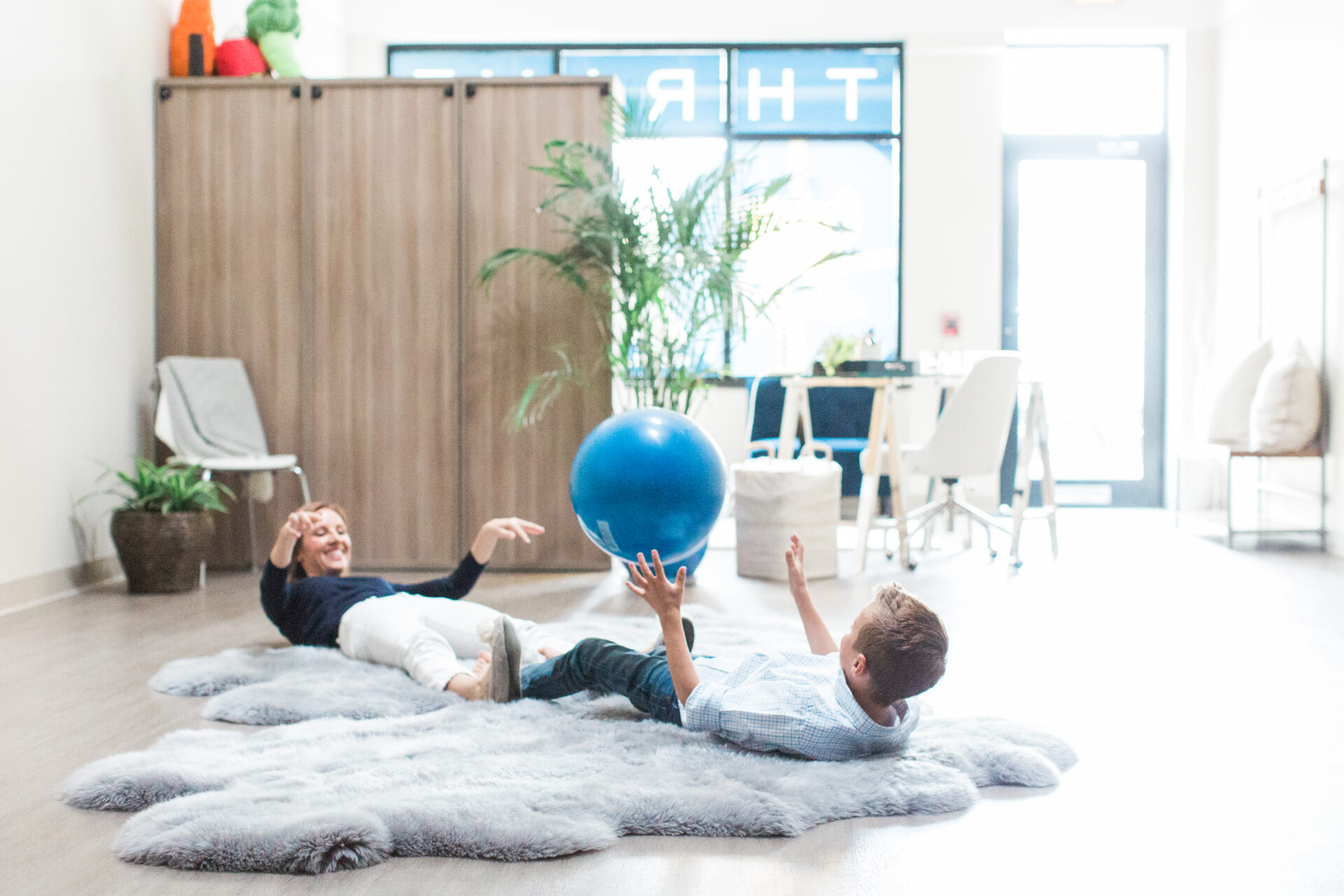 Children playing with blue ball indoors.