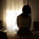 Silhouette of woman sitting by window.