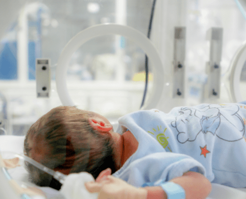 Newborn baby inside a hospital incubator.