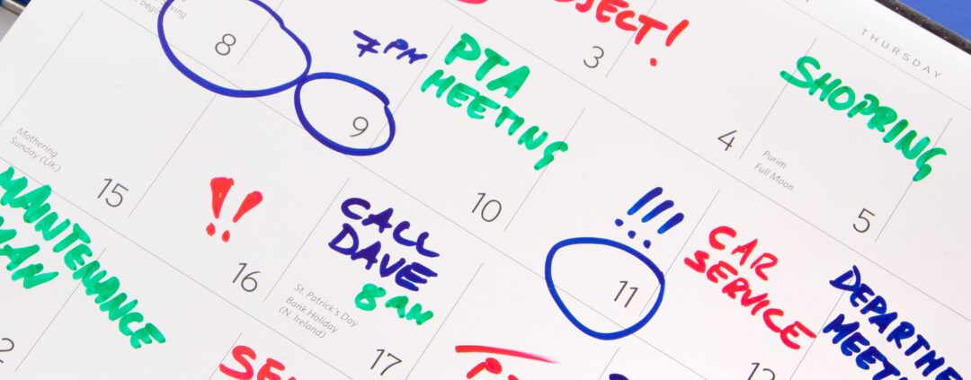 Marked monthly planner with colored notes and highlighters