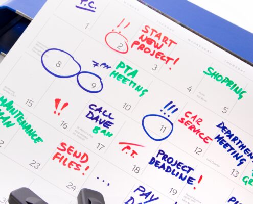 Marked monthly planner with colored notes and highlighters